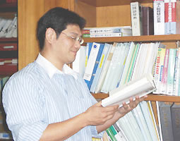 事務所内で書籍を読む佐藤税理士